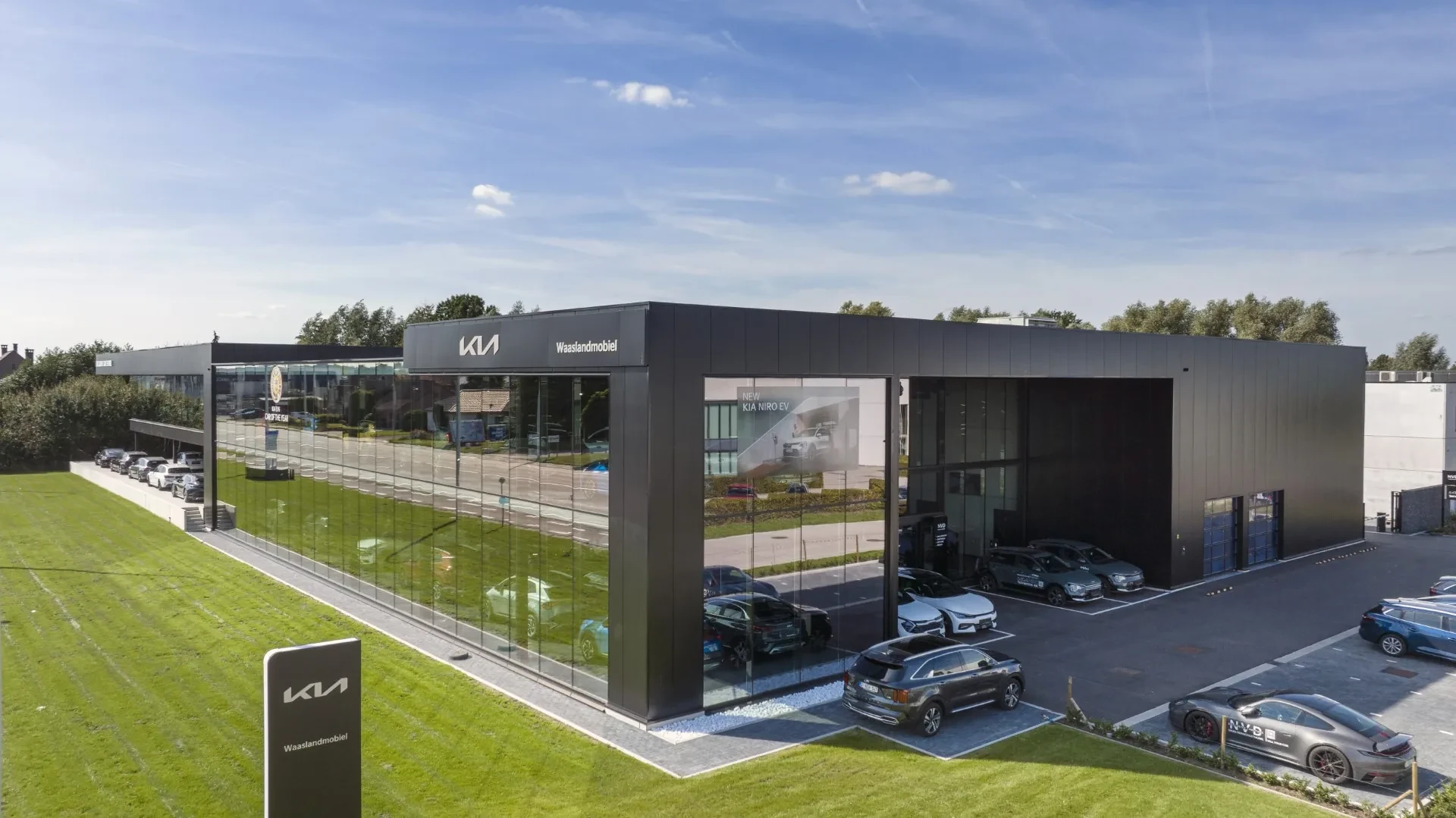 Ons gebouw aan de Moerputstraat 2 in Sint-Niklaas, met het Kia-logo en de showroom