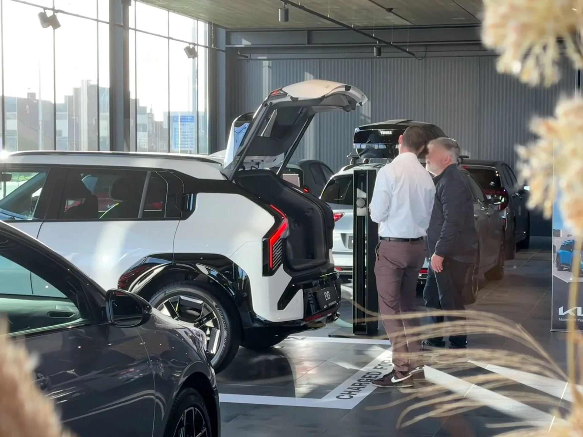 Een verkoper van Kia Waaslandmobiel met een klant bij een Kia in de showroom